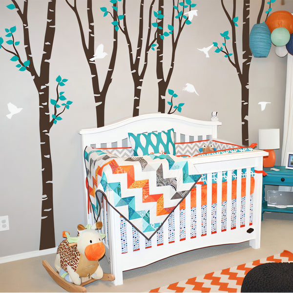Tree wall sticker with birds in a nursery with a crib.