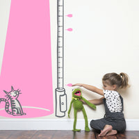 Height chart wall sticker of a cat bathed in light from a street lamp with a young girl playing with kermit the frog nearby.