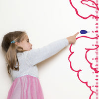 Height chart wall sticker of a monkey with a jetpack with a young girl pointing at their charted height.