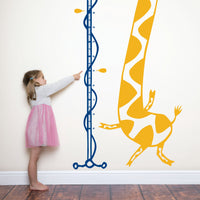 Height chart wall sticker of a giraffe singing into a microphone with a young girl nearby.