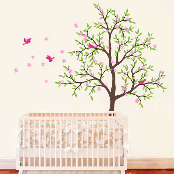 Tree wall sticker with leaves blowing and birds in a nursery with a crib.