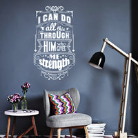 Wall quote sticker with text "I Can Do All This Through Him Who Gives Me Strength" in a living space with a small table, chair and floor lamp.