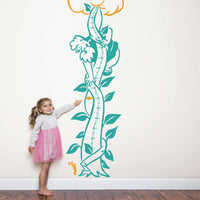 Height chart wall sticker of jack and the giant beanstalk with a young girl nearby.