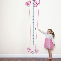 Height chart wall sticker of a kite being flown by a cat and dog with a young girl nearby.