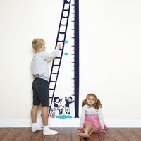 Height chart wall sticker of a kitten being rescued from a tree with a young boy and girl nearby.