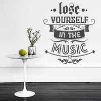 Wall quote sticker with text "Lose Yourself In The Music" next to a small table.