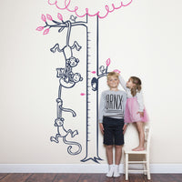Height chart wall sticker with monkeys hanging from a tree to form a chain with a young boy and girl nearby.