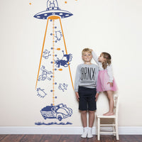 Height chart wall sticker of a UFO abducting a car with a young boy and girl nearby.