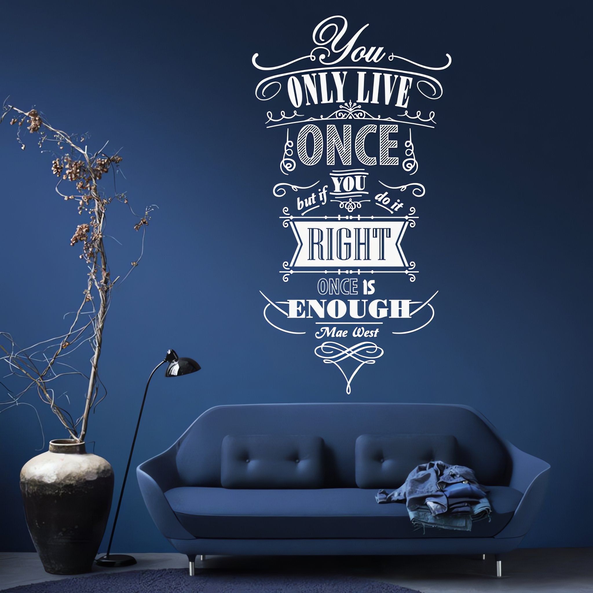 Wall quote sticker with text "You Only Live Once But If You Do It Right Once Is Enough" in a blue room with a couch and a potted plant.