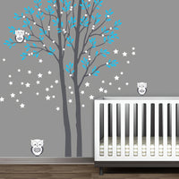 Tree wall sticker with leaves falling and 2 owls in a nursery with a crib.