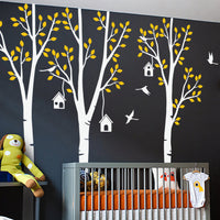 Tree wall sticker with leaves, birdhouses and birds in a nursery with a crib.