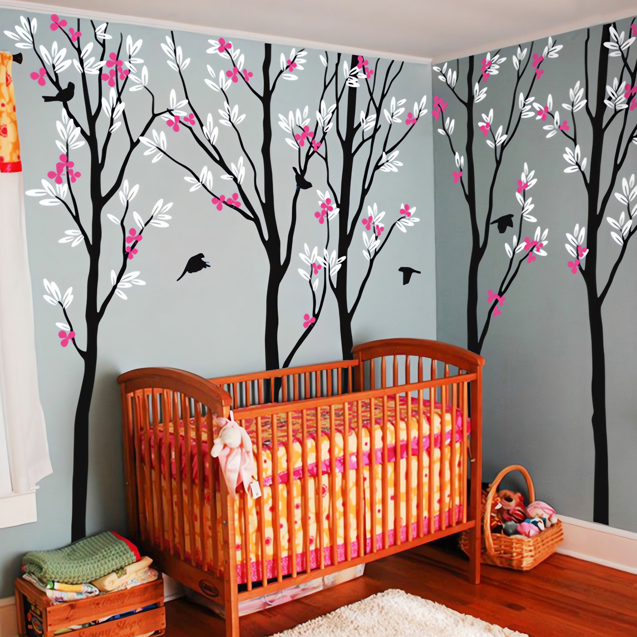 Tree wall sticker with birds in a nursery with a crib.