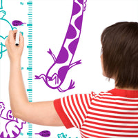 Height chart wall sticker with animals on a trampoline with a mother charting the height of their child.
