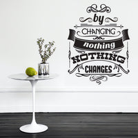 Wall quote sticker with text "By Changing Nothing, Nothing Changes" next to a small table.