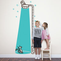 Height chart wall sticker of a cat bathed in light from a street lamp with a young boy and girl nearby.