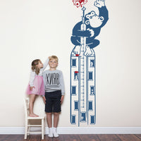 Height chart wall sticker of King Kong atop a sky scraper with a young boy and girl nearby.