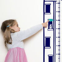 Height chart wall sticker of King Kong atop a sky scraper with a young girl pointing at their charted height.