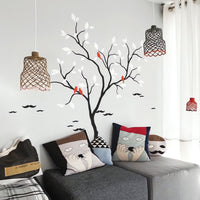 Tree wall sticker with birds in a bedroom or living room near seating.