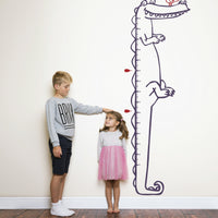 Height chart wall sticker of a cartoon crocodile with a young boy and girl nearby.