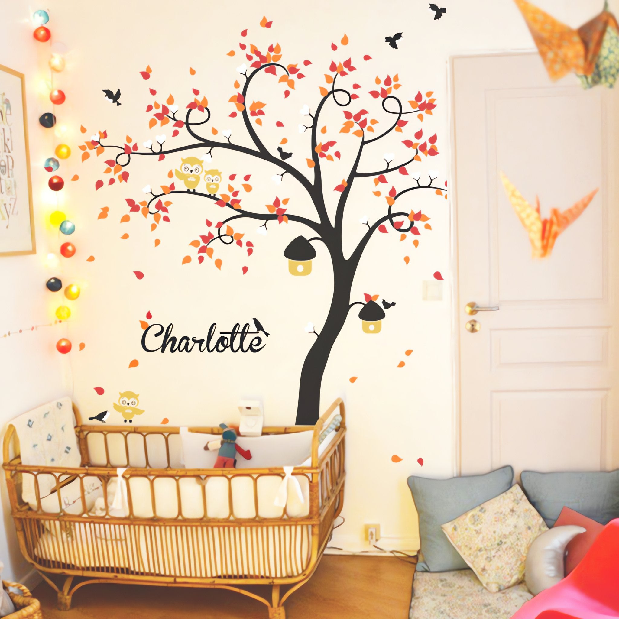 Tree wall sticker with curved trees, birds, owls and the name of a significant loved one in a nursery with a crib and a chair.