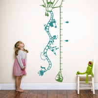 Height chart wall sticker of a hot air balloon taking off with a young girl and kermit the frog nearby.