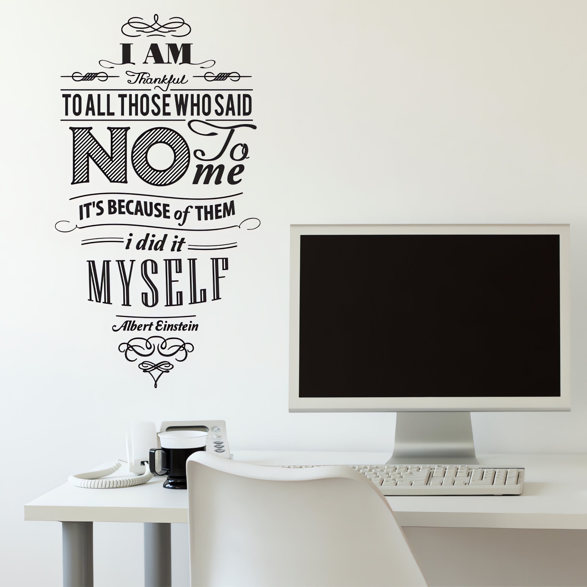 Wall quote sticker with text "I Am Thankful To All Those Who Said No To Me It's Because Of Them I Did It Myself" in an office with a computer screen,a desk and a chair.