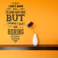Wall quote sticker with text "I Don't Know Where I Am Going From Here But I Promise It Won't Be Boring" next to a shelf with a potted flower.