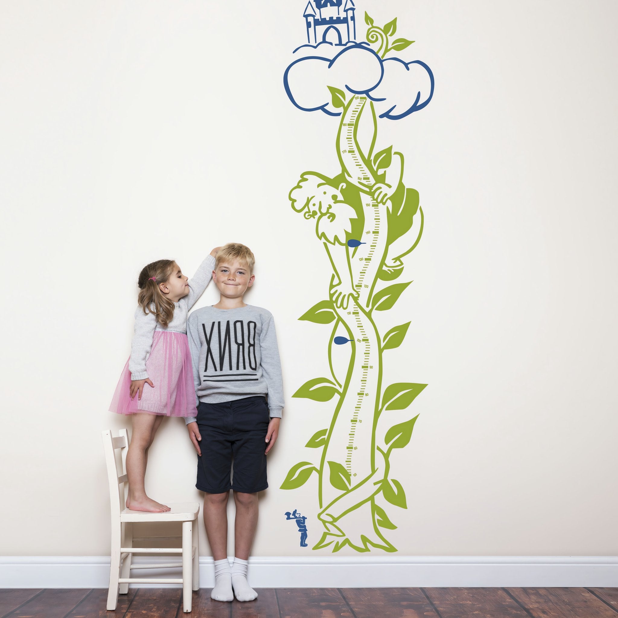 Height chart wall sticker of jack and the giant beanstalk with a young boy and girl nearby.