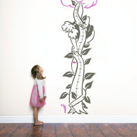 Height chart wall sticker of jack and the giant beanstalk with a young girl nearby.