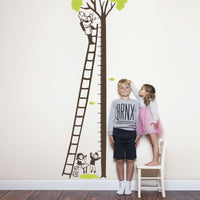 Height chart wall sticker of a kitten being rescued from a tree with a young boy and girl nearby.