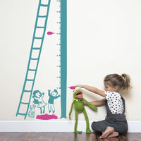 Height chart wall sticker of a kitten being rescued from a tree with a young girl playing with kermit the frog nearby.