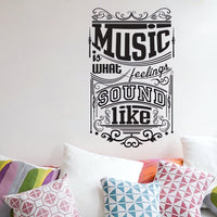 Wall quote sticker with text "Music Is What Feelings Sound Like" above seating area with lots of cushions.