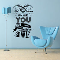 Wall quote sticker with text "No Matter How Hard You Try You'll Never Be As Cool As Bowie" in a sparse room with a floor lamp and chair.