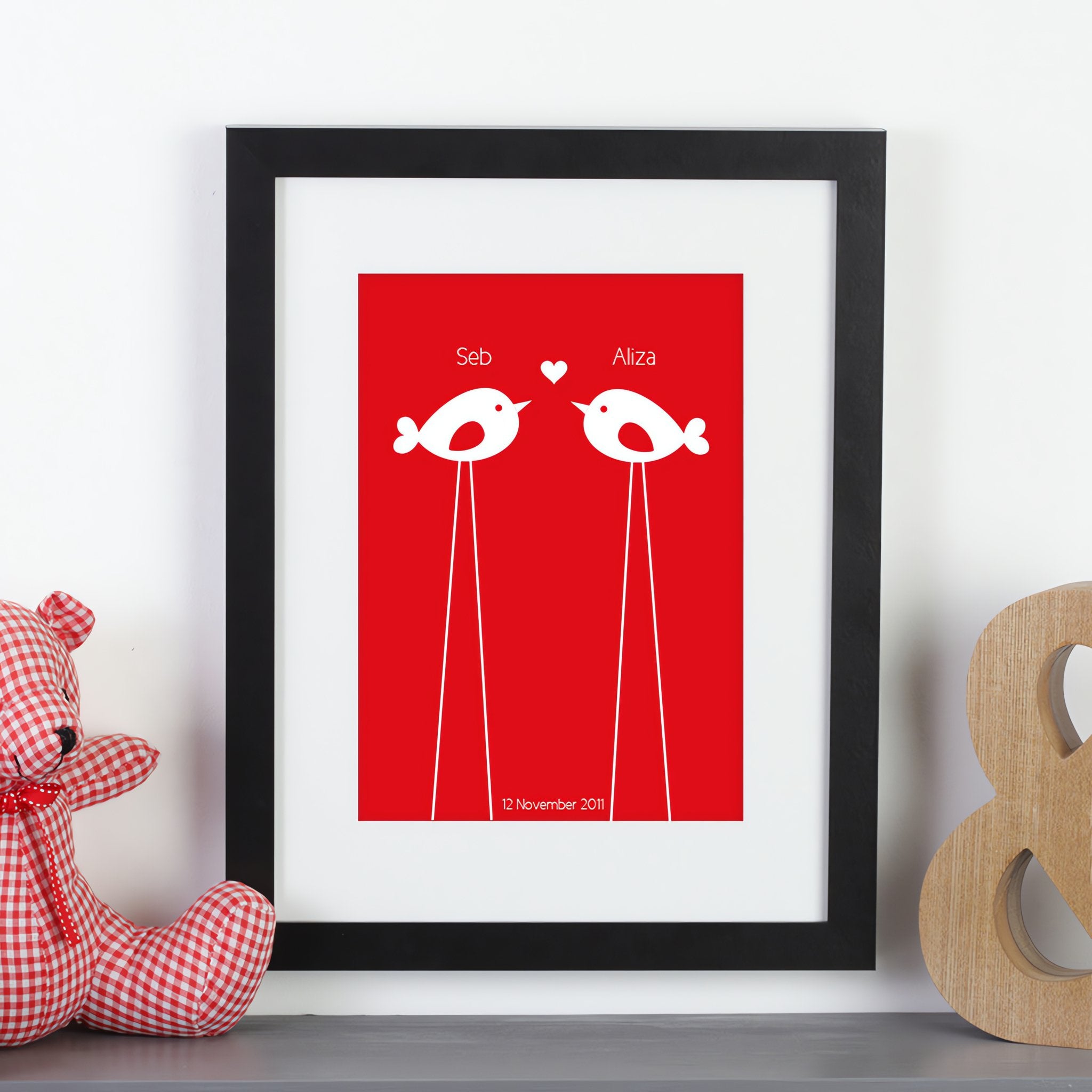 Personalized framed print with 2 birds with names and a date next to a teddy bear.