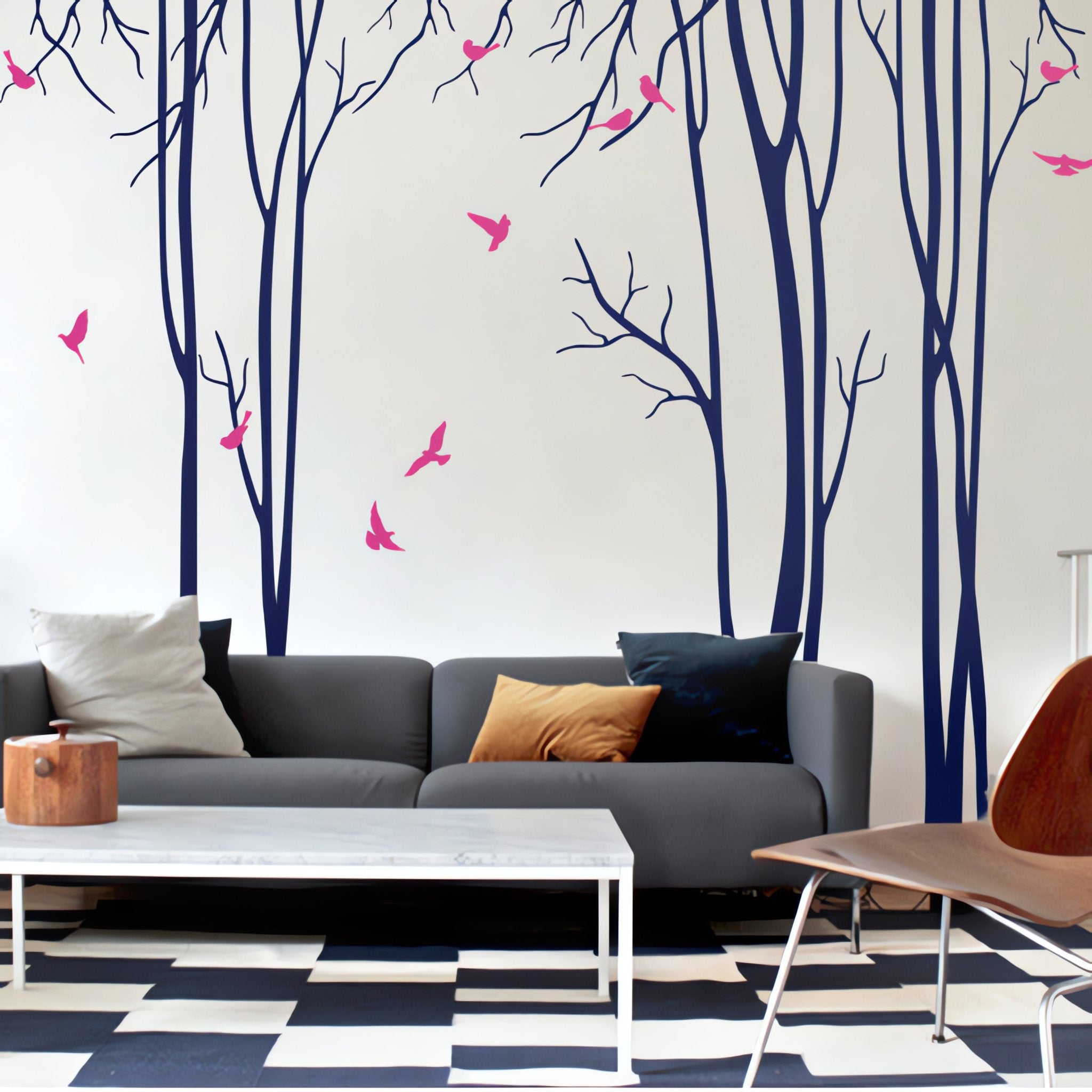 Tree wall sticker with stylish tall thin trees and birds in a living room with a coffee table, a sofa and a chair.