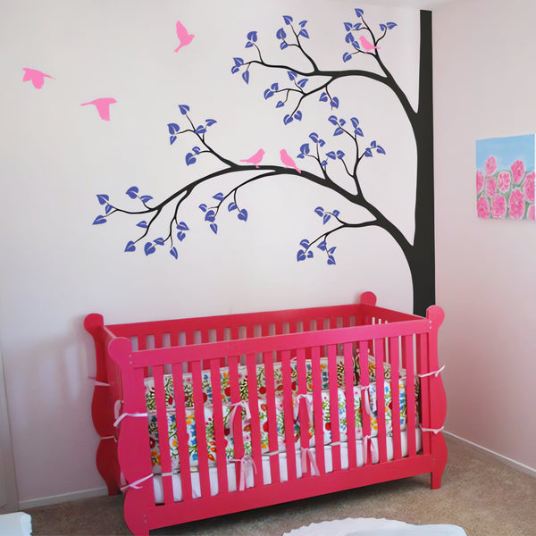 Tree wall sticker with branches on the left and birds in a nursery with a crib.
