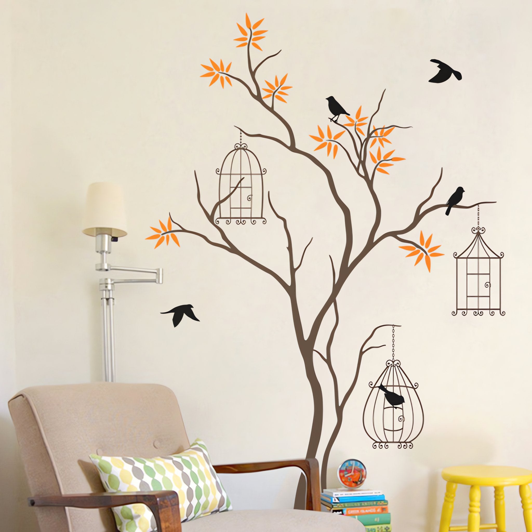 Tree wall sticker of birds and bird cages in a room with a comfy chair.