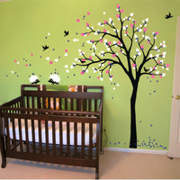 Tree wall sticker with birds and hedgeogs in a nursery with a crib.