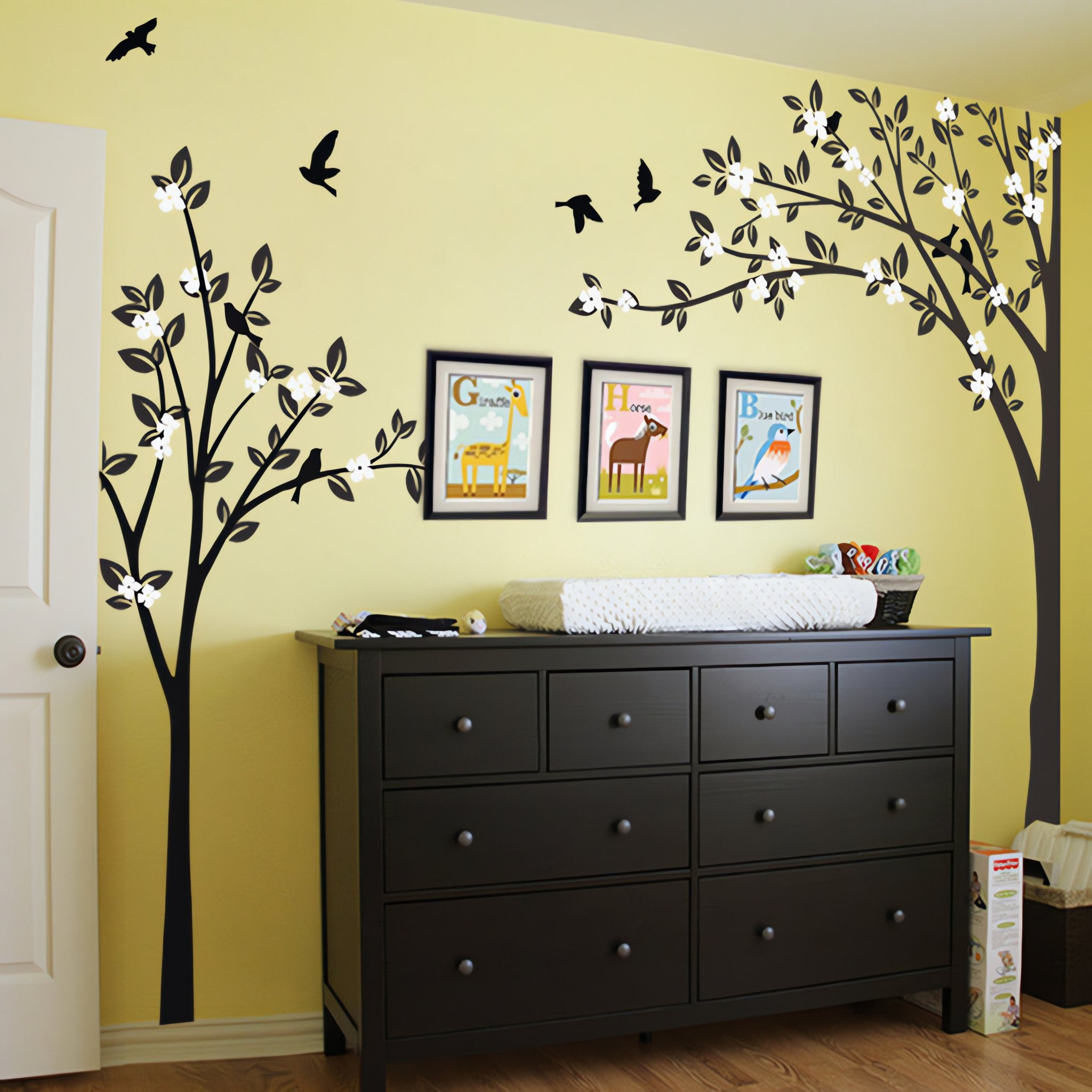 Tree wall sticker with2 trees and birds in a room with framed pictures and a dresser.