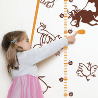 Height chart wall sticker of a UFO abducting a car with a young girl pointing to her charted height.
