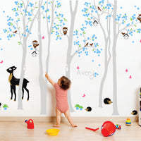 Tree wall sticker with lots of animals and the name of a loved one in a nursery with a child playing and lots of toys.