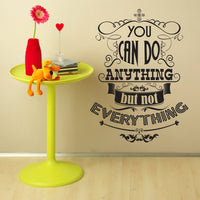 Wall quote sticker with text "You Can Do Anything But Not Everything" next to a small plastic table.